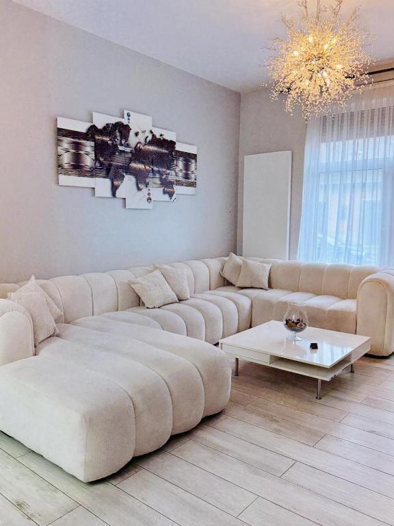 a living room with a large couch and a table at l'imperial WIFI & Confort in Brussels