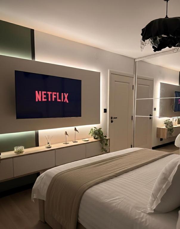 a bedroom with a bed with a television on the wall at Sage Studio in Drobeta-Turnu Severin