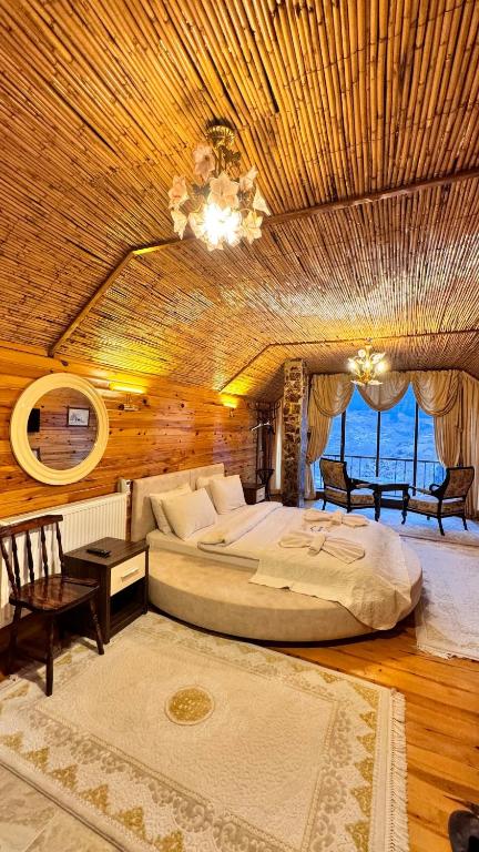 ein großes Schlafzimmer mit einem großen Bett und einem Kronleuchter in der Unterkunft İsgobya Chalets 103 in Macka