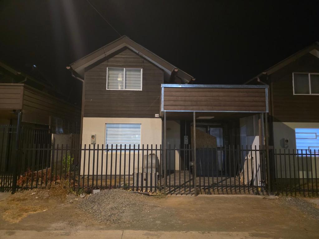 a house with a fence in front of it at night at Villa Parque Cordillera 1 in Chillán