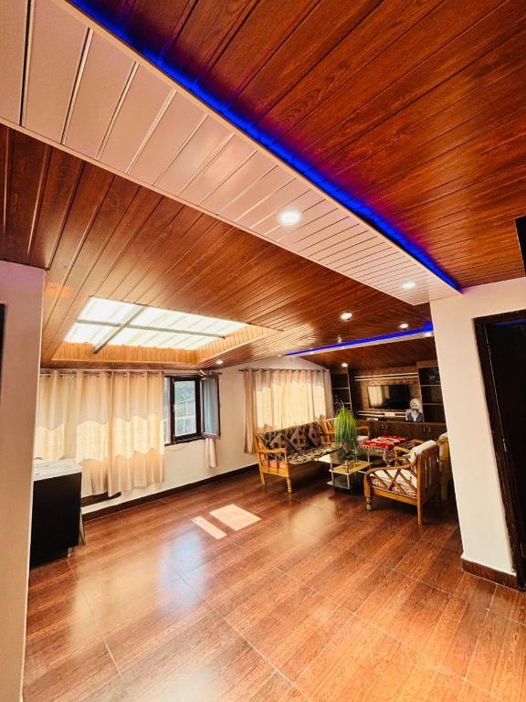 a large living room with a blue light on the ceiling at Pinewood View Homestay in Shimla