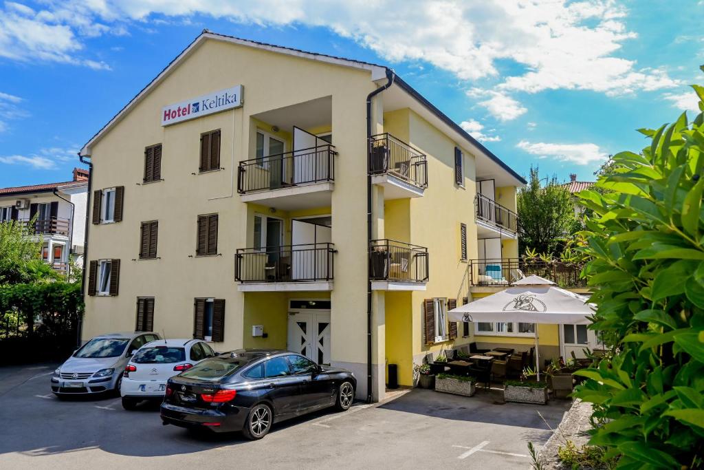 un edificio con auto parcheggiate di fronte di Garni Hotel Keltika a Izola