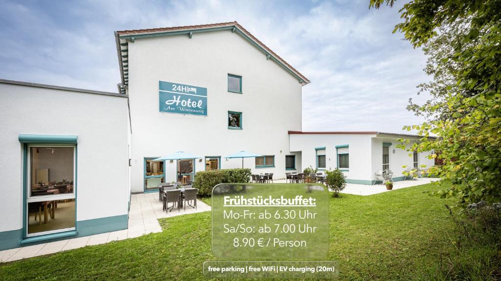 a building with a sign in front of it at Hotel Am Wiesenweg l 24h check-in in Hausen