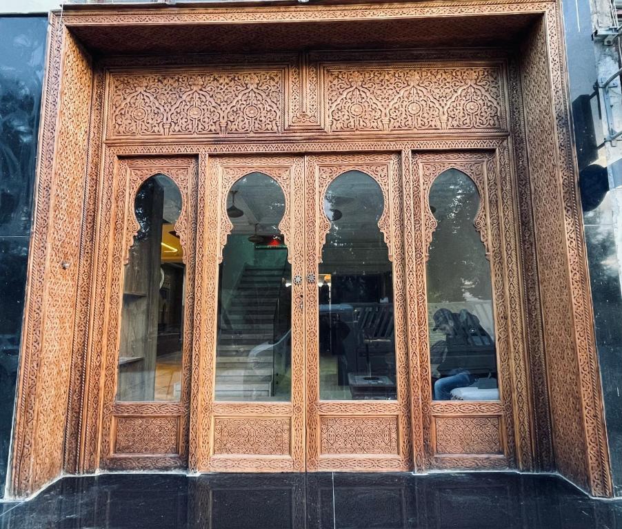 a wooden door with many windows on a building at Hôtel kairouan in Fez