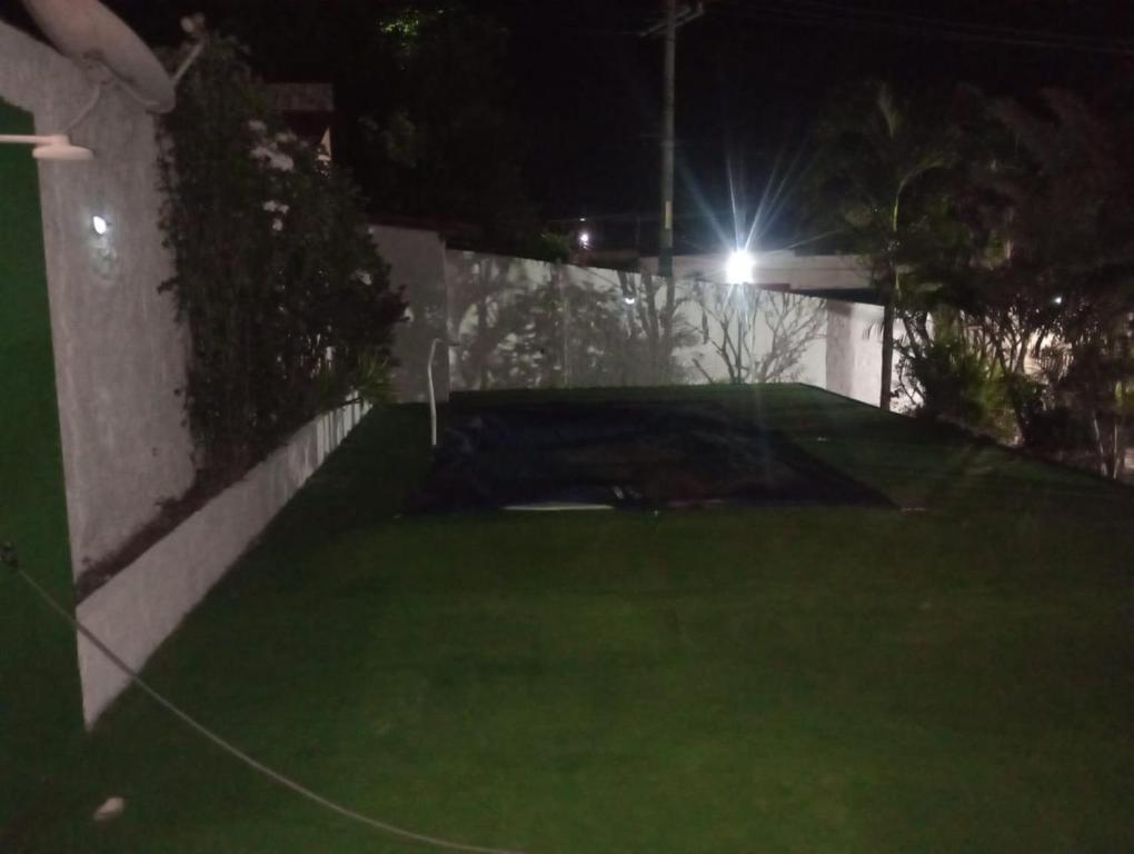 a view of a backyard at night with a golf course at Recanto do alberto in Camacari