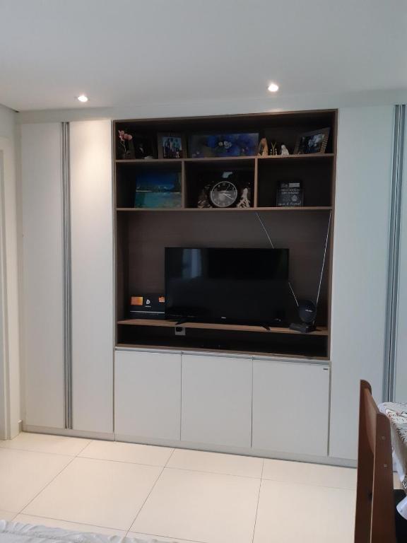 a living room with a tv on a wall at Kitnet acolhedora in Caxias do Sul