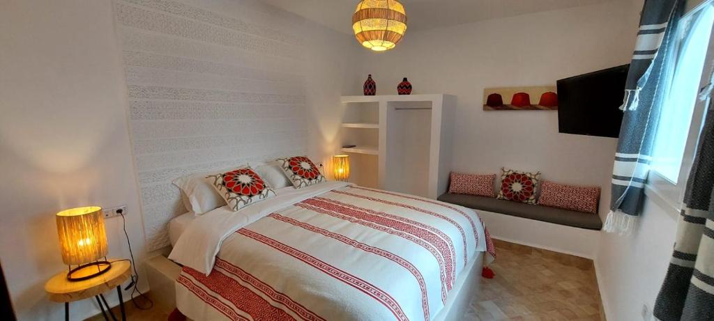 a bedroom with a large white bed with two lamps at Hôtel Riad La Nouvelle Etoile - Agadir in Agadir
