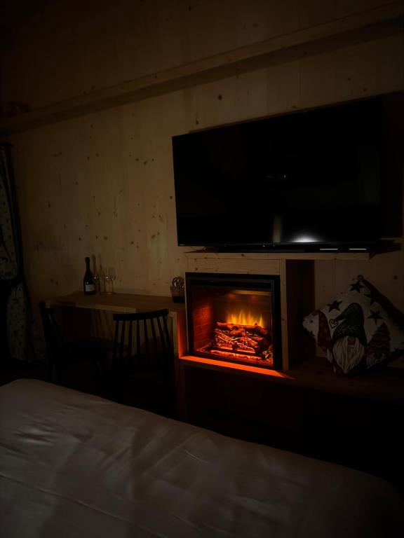 Zimmer mit Kamin und TV darüber in der Unterkunft Appartamenti Casa Sabry in San Niccolò Comèlico