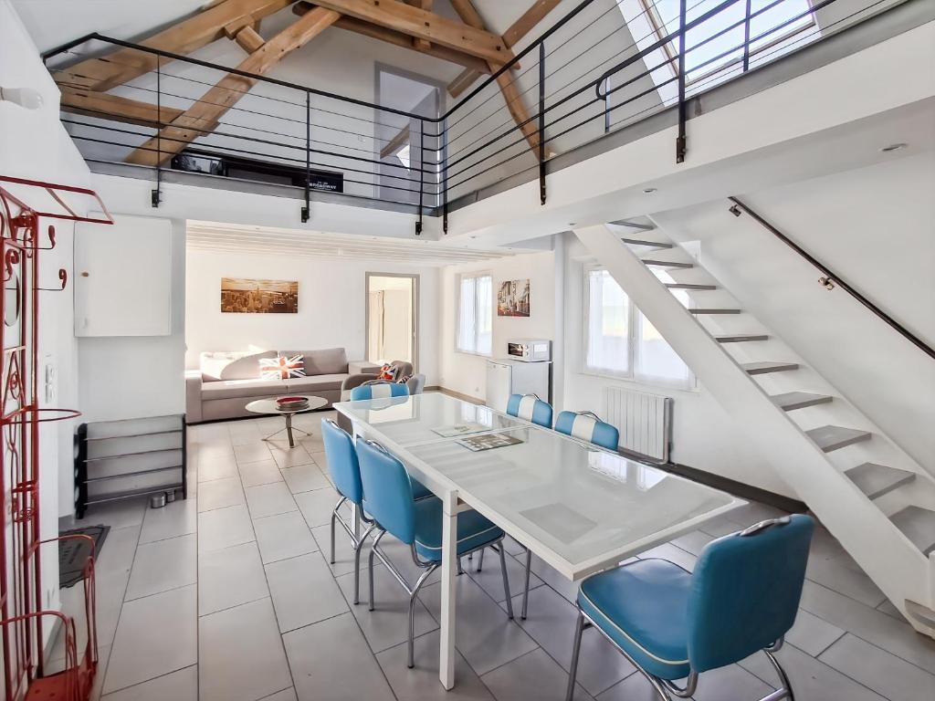 een eetkamer met een tafel en blauwe stoelen bij Gîte de la Petite Forge in Clévilliers