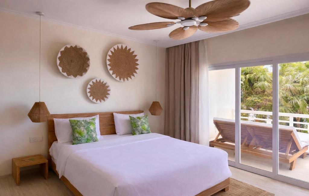 een slaapkamer met een bed en een plafondventilator bij Cocoon in Anse a La Mouche