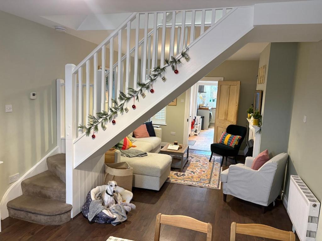 a living room with a dog laying on the floor under a staircase at 2 Bed Terrace Cottage with Cathedral Views in Salisbury