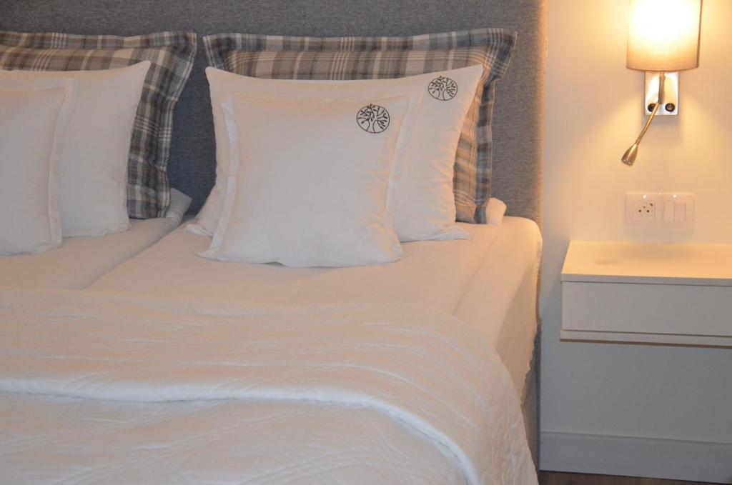 een bed met witte lakens en kussens in een kamer bij Spokojnia in Lubrza