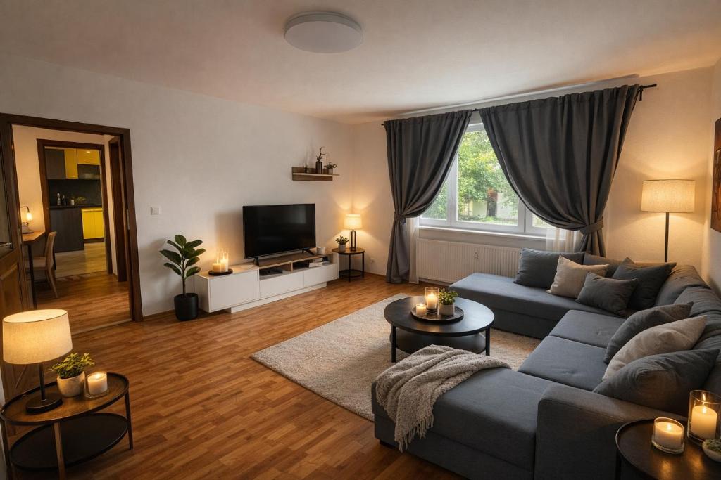 a living room with a blue couch and a tv at 3BR near Center with Parking in Bratislava