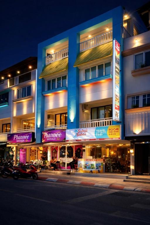 a building with purple signs on the side of it at Three Monkeys Chaweng Beach in Chaweng