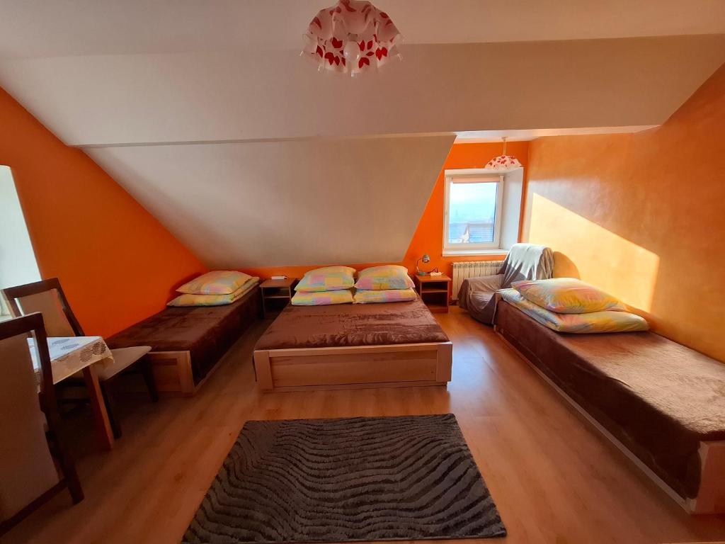 a attic room with three beds and a chandelier at Atticapartament in Kluszkowce