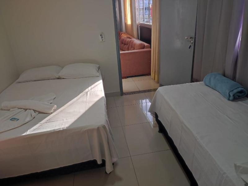 two beds in a small room with a mirror at Estrela de davi in Goiânia