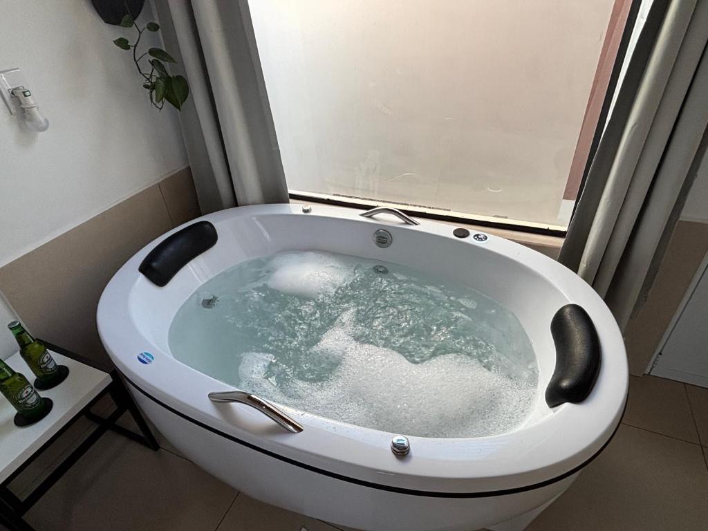 een badkuip in een badkamer met een raam bij Ofurô com hidromassagem aquecida in Guia Lopes da Laguna