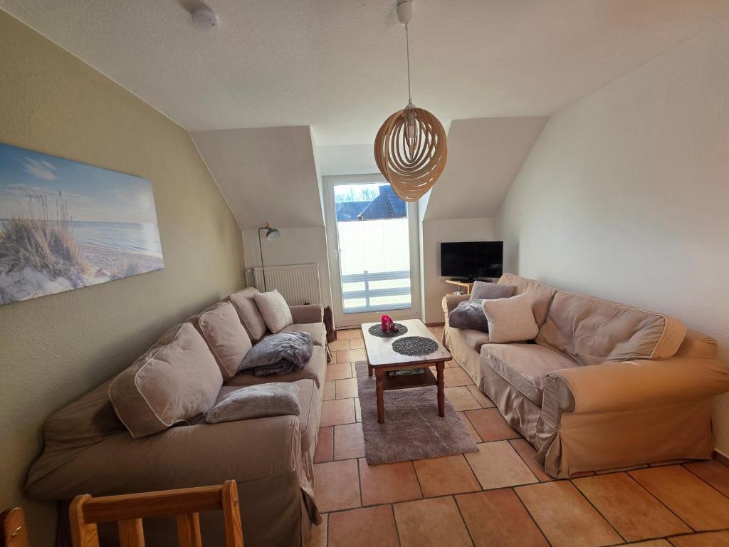 a living room with two couches and a table at Fewo LucGa in Zingst