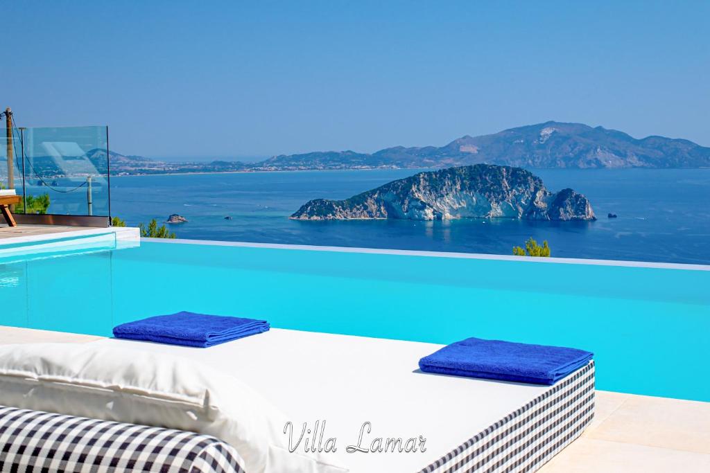 a pool with a bed and a view of the ocean at Lamar Private Luxury Villas in Marathias