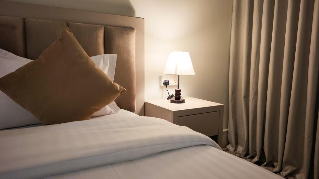 a bedroom with a bed with a pillow and a lamp at نوف بلازا nouf plaza for serviced apartments in Ad Dawādimī