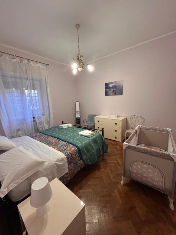 een slaapkamer met 2 bedden en een kinderbedje. bij Casa Cristina in Marino