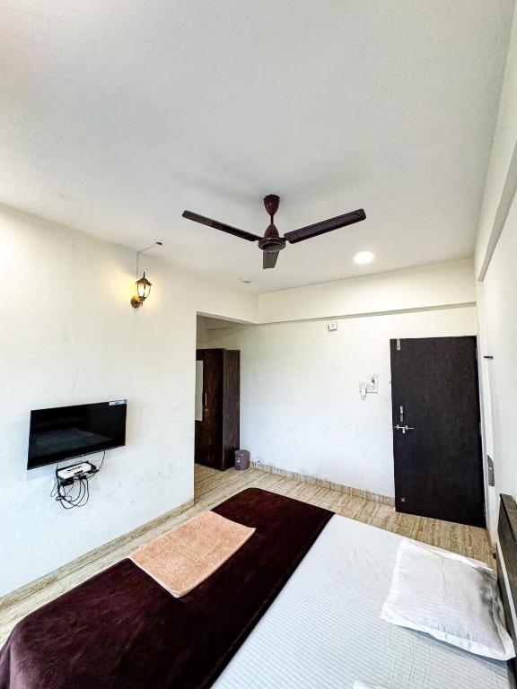 a room with a bed and a ceiling fan at Horizon cottage in Nagaon