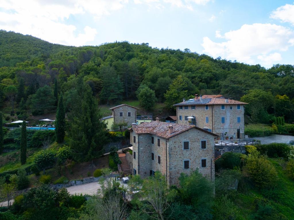 een groep gebouwen op een heuvel naast een rivier bij Agriturismo L'Essiccatoio in Lisciano Niccone