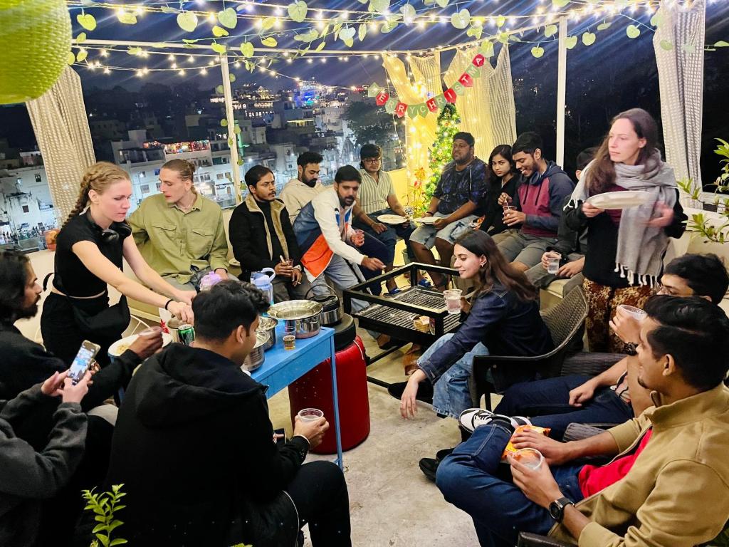 a group of people sitting in a crowd in a tent at Turtle Hostel Udaipur- 10 mtr from Lake in Udaipur