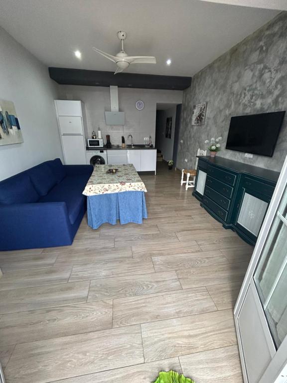 een woonkamer met een blauwe bank en een tafel bij Apartamentos Turisticos Ilusiones 2 in Cazalla de la Sierra