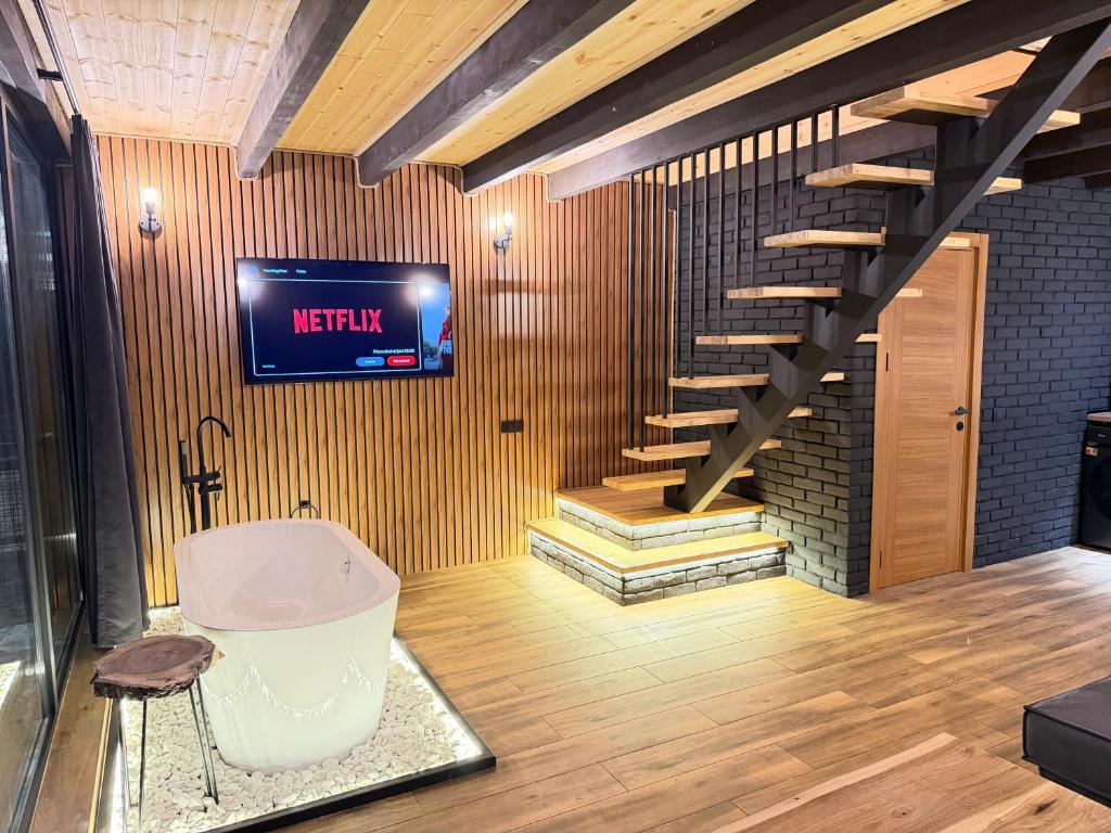 een badkamer met een bad en een tv aan de muur bij Kazbegi Story in Kazbegi