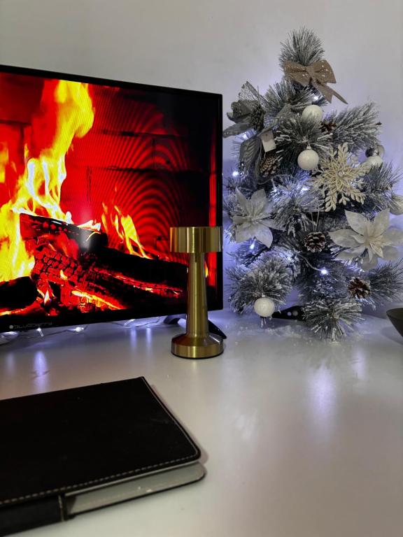 een computermonitor met een kerstboom en een open haard bij Villa Conceptt casa in Jasenak