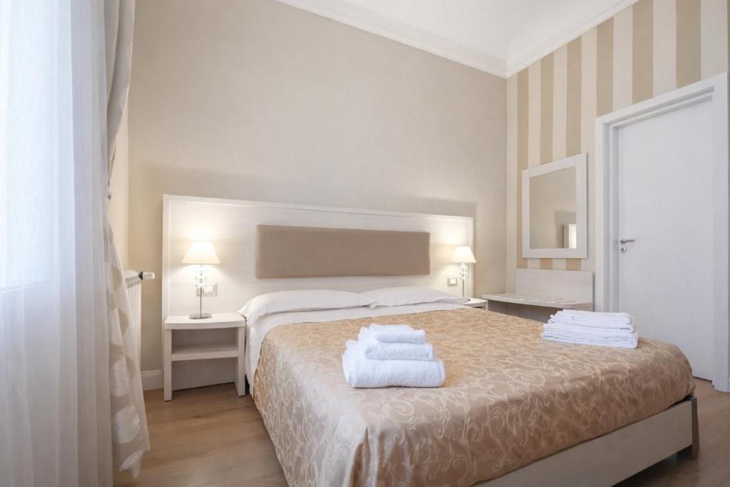 een slaapkamer met een bed met handdoeken erop bij Opera Relais in Messina