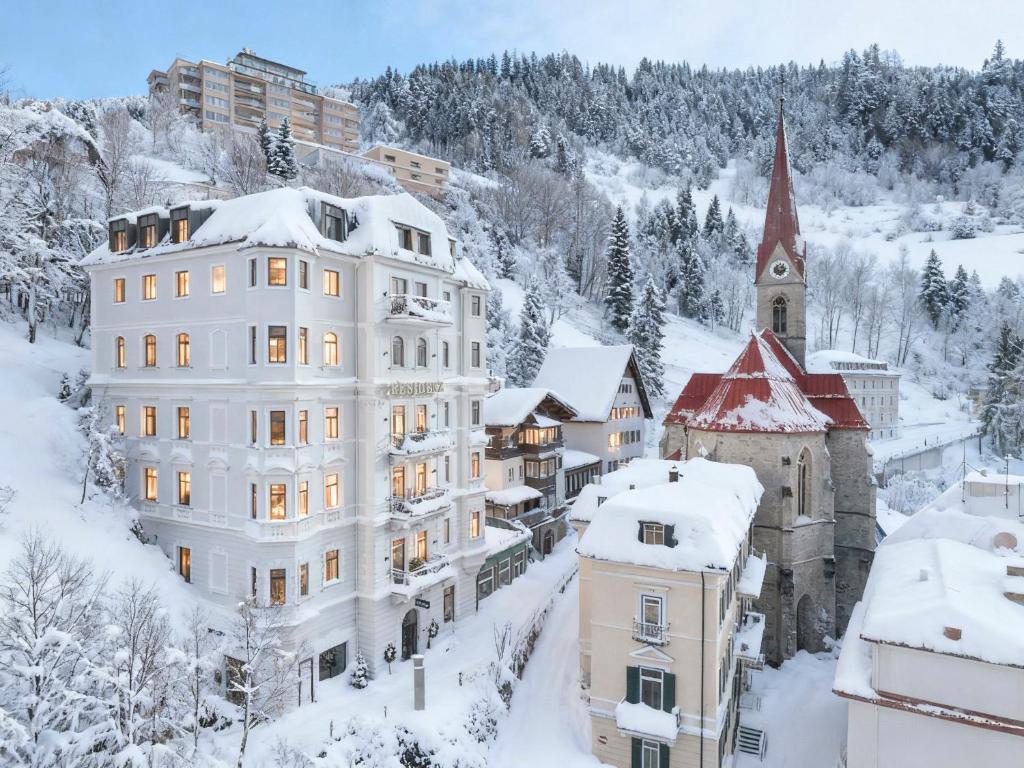 een stad in de sneeuw met een kerk bij Residenz Boutique Suites in Bad Gastein