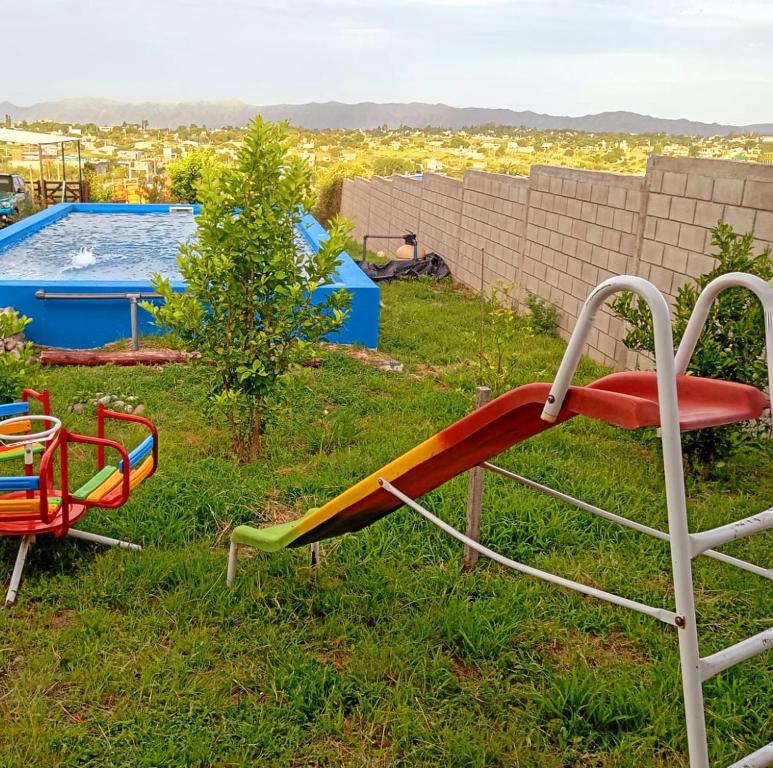 een glijbaan in het gras naast een zwembad bij Brisas de las Sierras in Tanti
