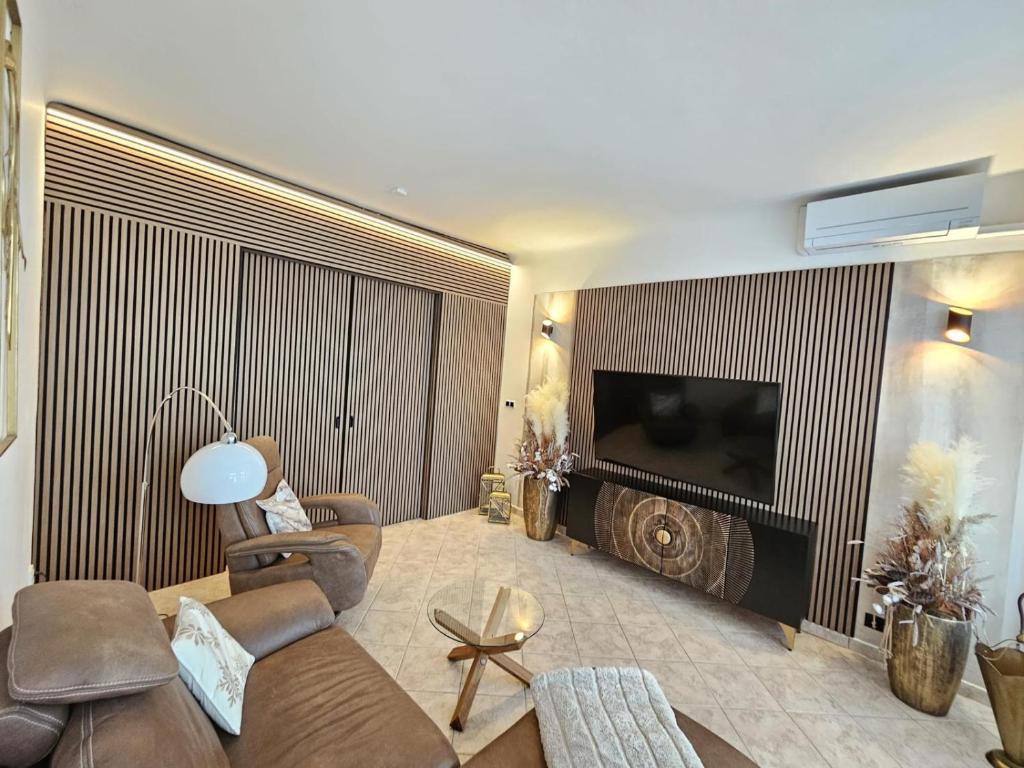 een woonkamer met een bank en een televisie bij Apartmán GREEN in Vysoké Mýto