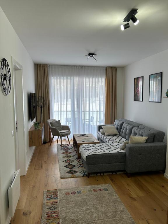 a living room with a couch and a chair at Apartman MAD Bjelasnica in Bjelašnica