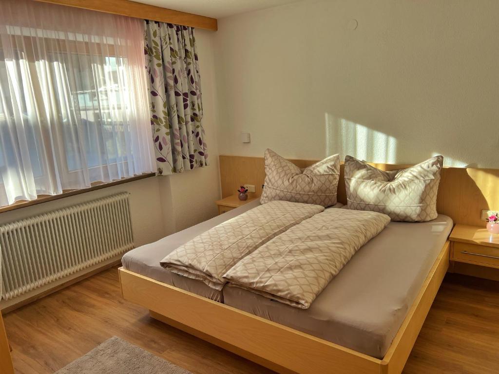 a bedroom with a large bed with a window at Appart Leni in Pfunds