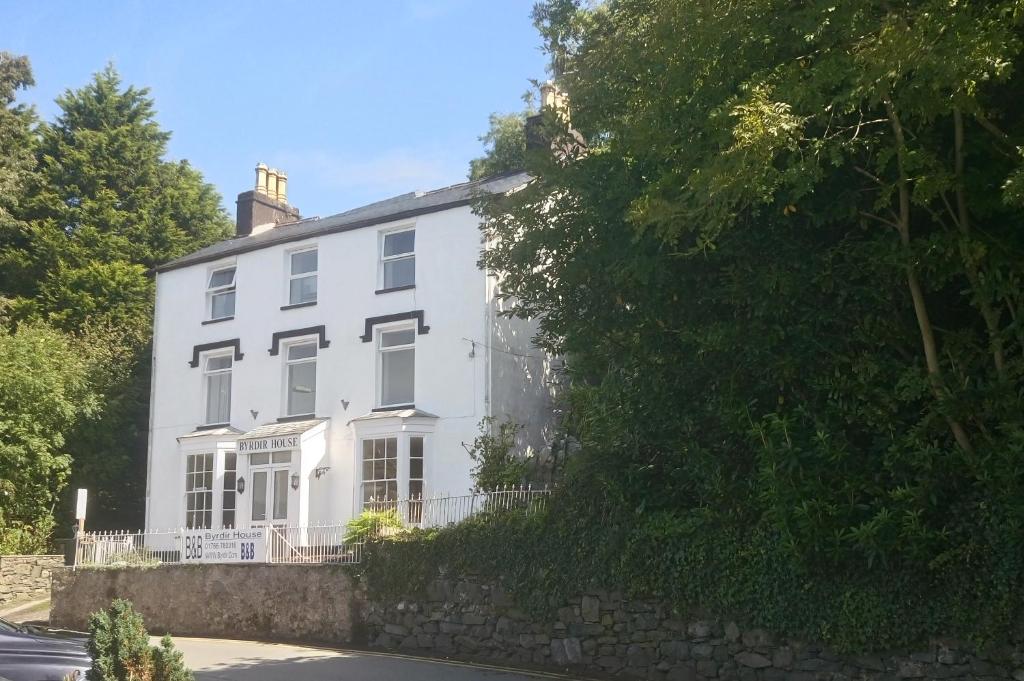 a white house on the side of a street at Byrdir House in Harlech