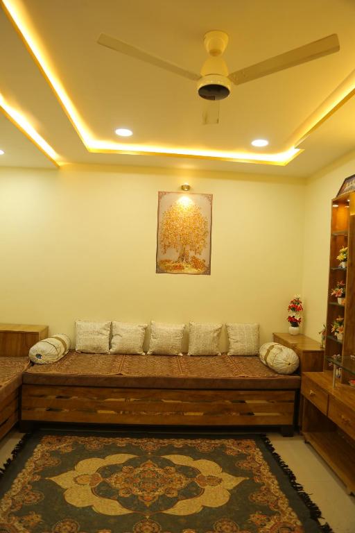 a living room with a long wooden couch at ShivAOM Family Homestay in Ujjain