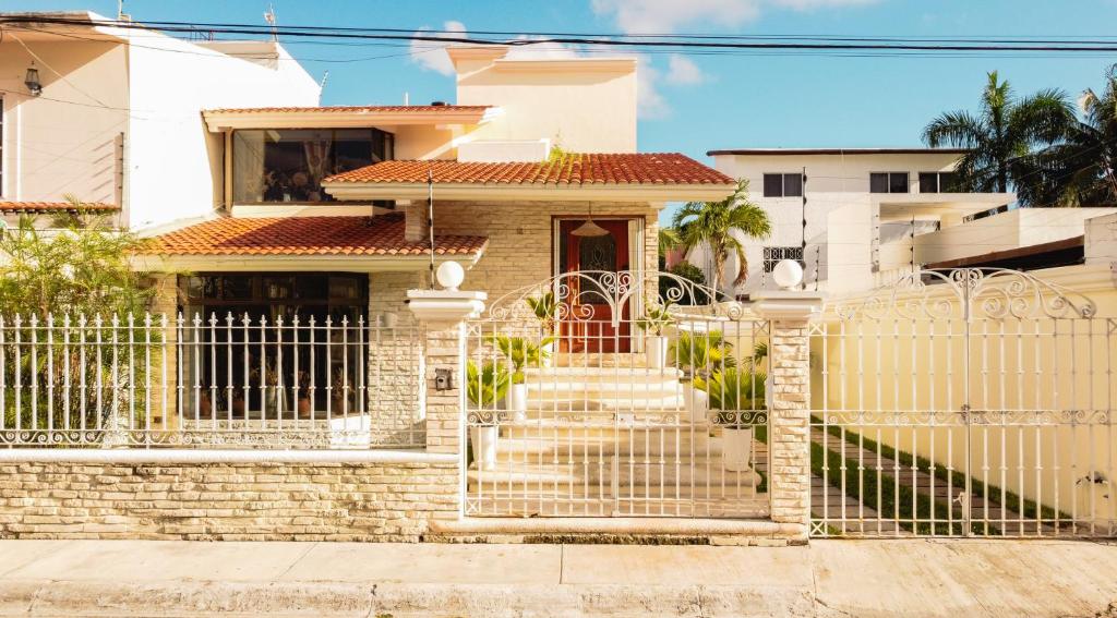 a white fence in front of a house at Casa con alberca privada 3BR Ideal para familias y grupos Hasta 9 personas in Cancún