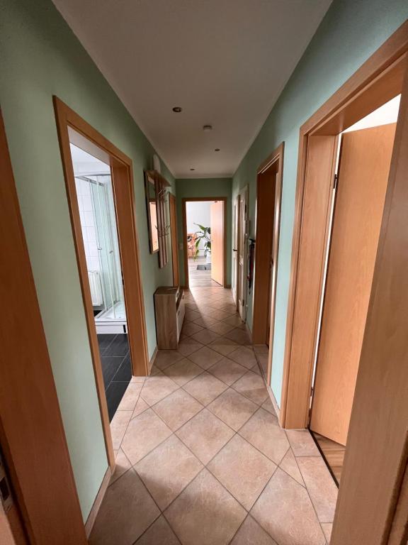 ein Flur eines Hauses mit grünen Wänden und einem Fliesenboden in der Unterkunft Ferienwohnung Unger in Großhartmannsdorf