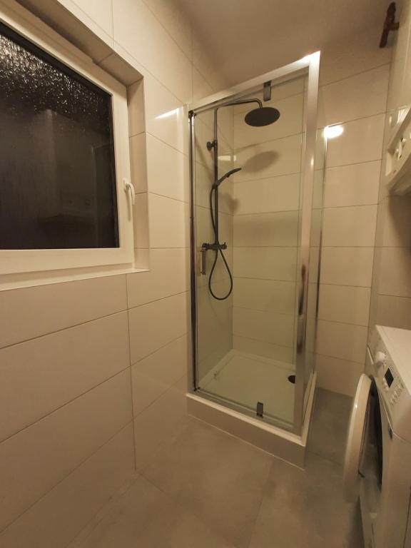 a shower with a glass door in a bathroom at Czapury in Czapury