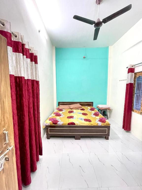 a bedroom with a bed and a red curtain at Bajrang kutirr in Varanasi
