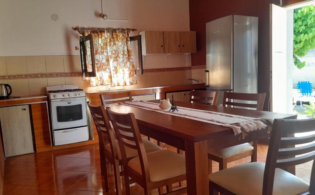 een keuken met een houten tafel met stoelen en een fornuis bij Los Velitos in Santa Rosa del Conlara