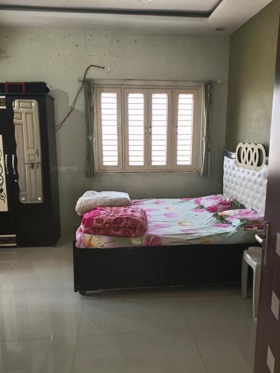 a bedroom with a large bed with a window at Keshav in Bhuj