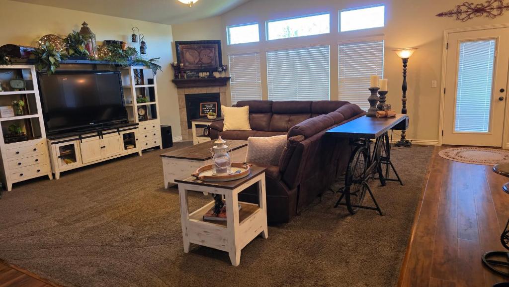 een woonkamer met een bank en een televisie bij Wasatch Retreat 5 bed 3 5 bath pool table game room in Layton