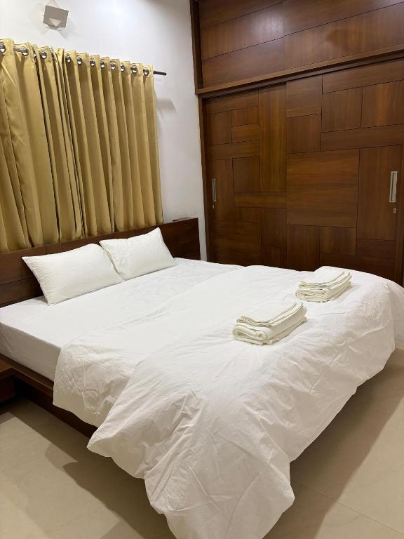 a bedroom with a bed with two towels on it at Ixe Stays in Mangalore