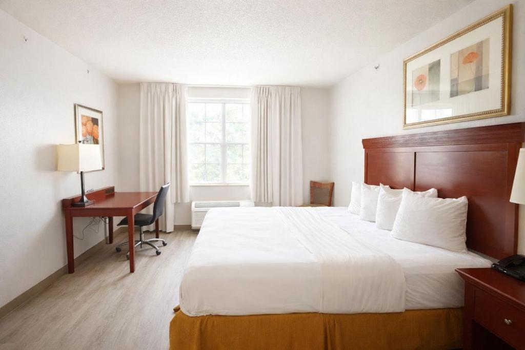 een hotelkamer met een groot bed en een bureau bij Seffner Inn and Suits in Seffner