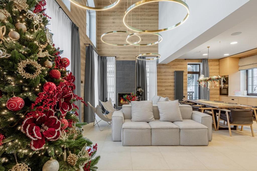 een kerstboom in een woonkamer met een bank bij Golden Chalet in Boekovel