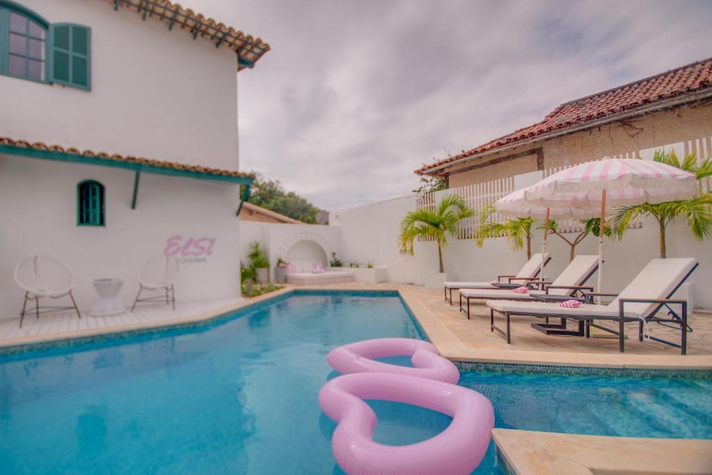 a swimming pool with pink inflatables in a house at Elsi Pousada in Búzios